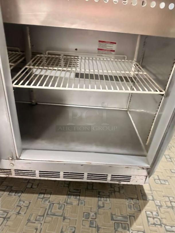 Beverage-Air SPE48HC-18M refrigerated sandwich table, immaculate condition, showing interior shelving and ventilation grates.