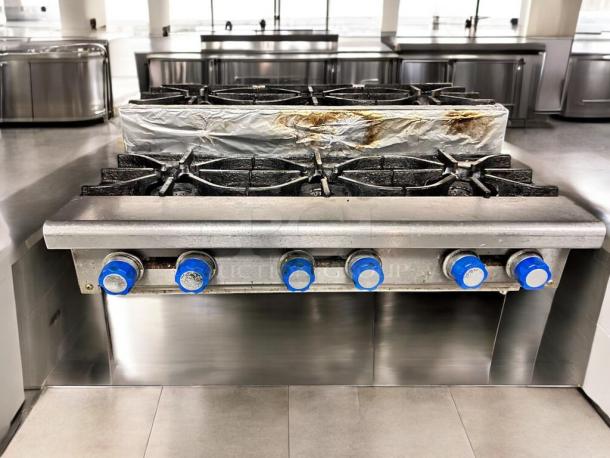 Imperial IHPA-8-48SU 48" gas hotplate, 8 burners, step-up design, excellent condition. Blue knobs, tested and working, natural gas.