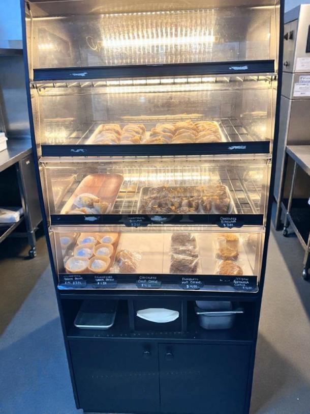 Outstanding condition Minus Forty BK-8 Shelf refrigerated bakery display case. Includes multiple shelves, interior lighting, and visible product labels. Fully tested and working.