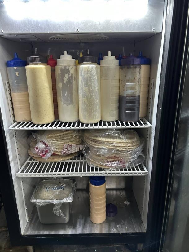 True GDM-07 24 1/8" Black Refrigerated Glass Door Merchandiser, amazing condition, stocked with condiments and wrapped items.