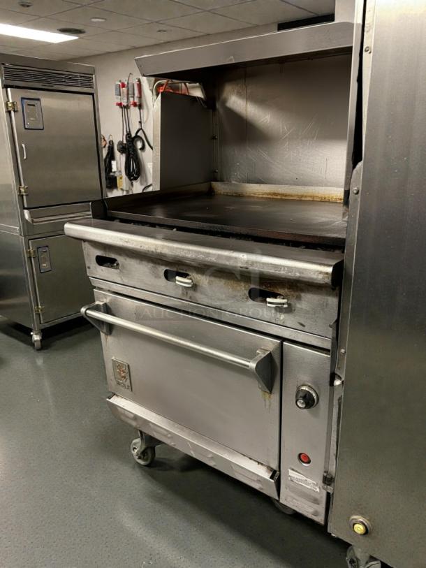 Wolf C36S-36G 36" gas range with full griddle and standard oven. Tested and working. Used condition, some wear visible.