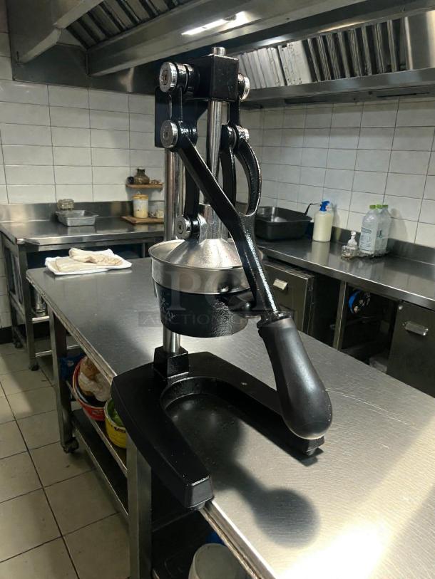 Zulay Kitchen cast-iron orange juice squeezer in working condition, heavy-duty design, visible Zulay branding on base.