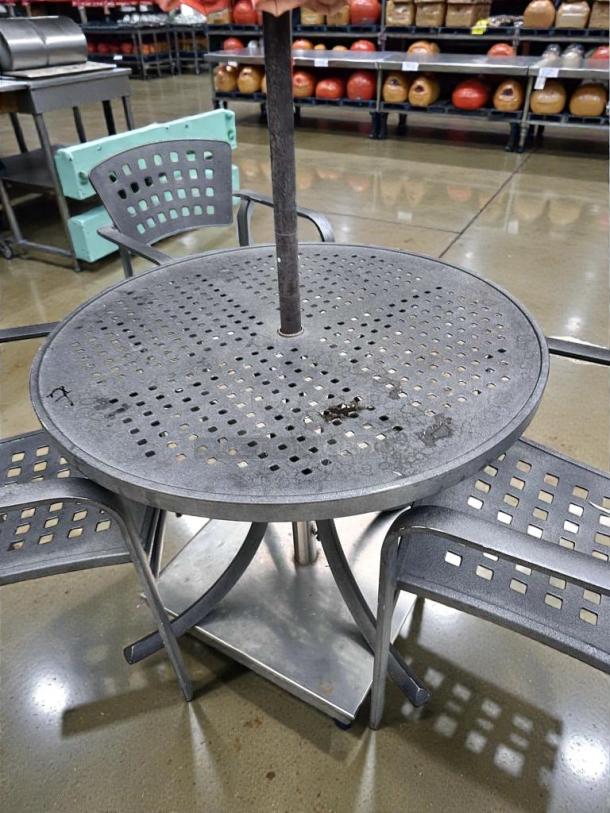 Pristine commercial round metal patio table with perforated top, umbrella-ready, fully inspected, and ready to use.