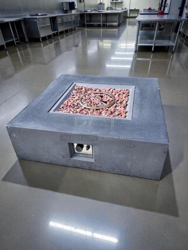 Outdoor gas fire pit table in pristine condition, square design, dark stone finish, filled with decorative rocks, fully tested and working.