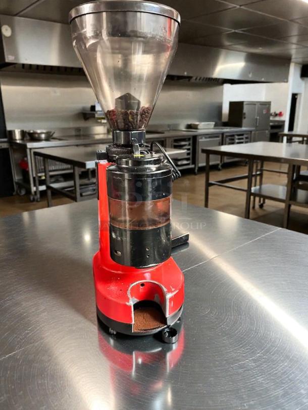 Commercial coffee grinder, premium condition, 120V, fully tested and working, red body, clear hopper, in a commercial kitchen setting.