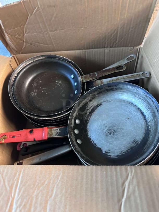 Lot of 22 commercial frying pans in a box, inspected and ready for use. Some signs of wear, sturdy metal handles.