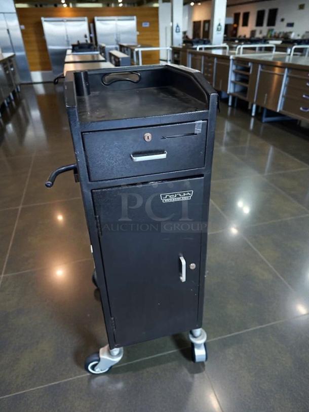Black restaurant service station cabinet, pristine condition, fully tested, with drawer and storage, on wheels for mobility.