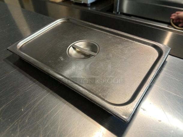 Choice full-size stainless steel slotted steam table pan cover in good condition, featuring a central handle.