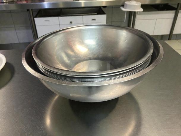 Choice stainless steel mixing bowls in excellent condition, sizes 9 1/2” to 16 1/2”, nested, shiny surface.