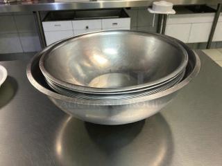 Choice stainless steel mixing bowls in excellent condition, sizes 9 1/2” to 16 1/2”, nested, shiny surface.