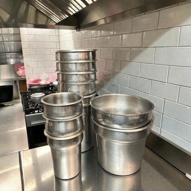 Vollrath vegetable insets in amazing condition, various sizes 6”-9.5” diameter, polished metal finish, stacked in a kitchen setting.