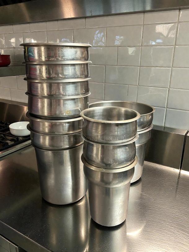 Vollrath vegetable insets, amazing condition, stainless steel, various sizes 6”-9.5” diameter, stacked on metal surface.