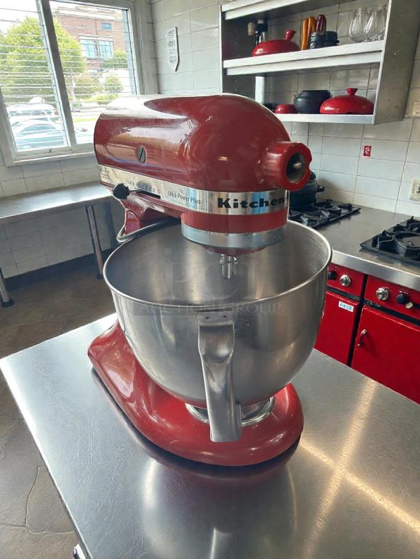 KitchenAid Artisan 5-qt red stand mixer in immaculate condition on a stainless steel counter, tested and working.