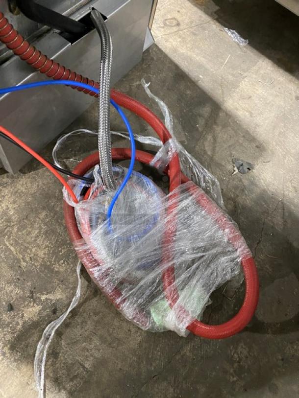 Coiled red and blue hoses wrapped in plastic, belonging to a Hobart Advansys LXer Series dishwasher.