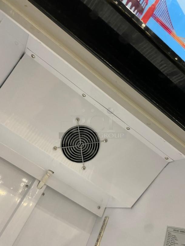 Dukers LG430F commercial refrigerator interior top view, showing ventilation fan and poly-coated wire racks, 115V.