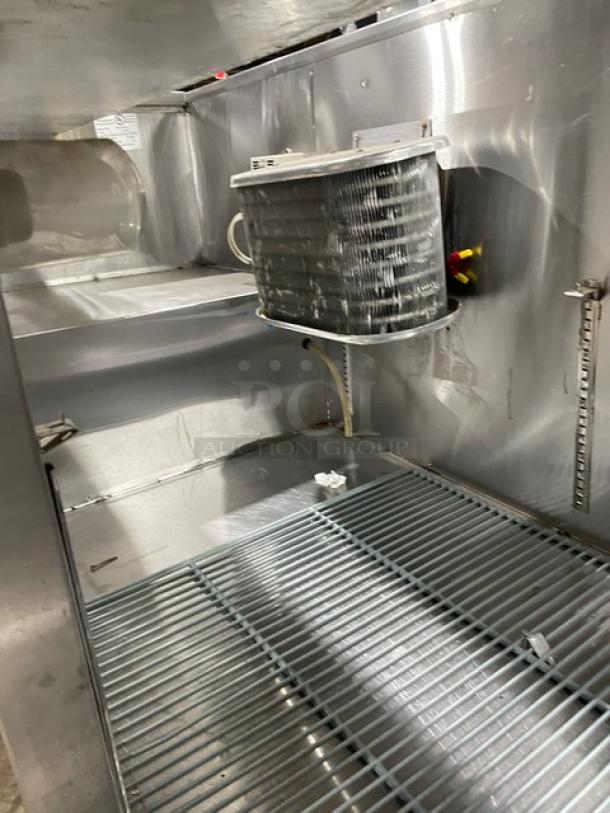 Leader stainless steel 2-1/2 door refrigerated prep table, poly coated rack, 115V 1 phase, on casters, interior view.