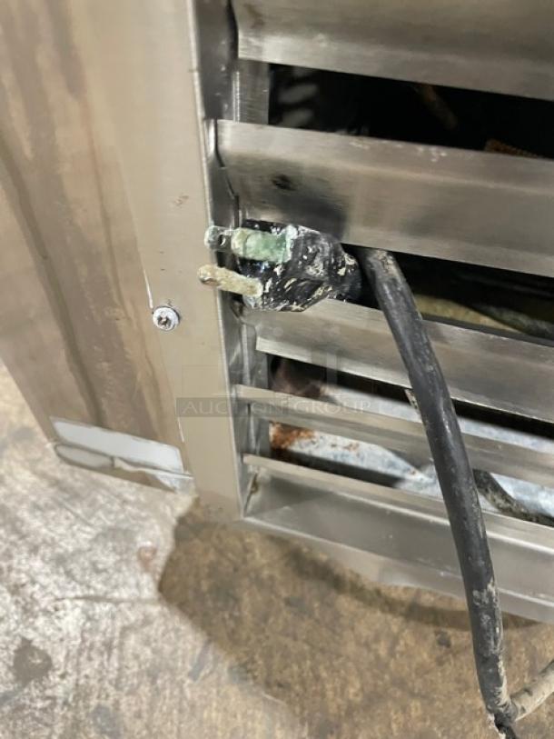 Leader commercial stainless steel prep table with a plug showing wear, on casters, includes poly-coated wire rack. 115V, 1 phase.