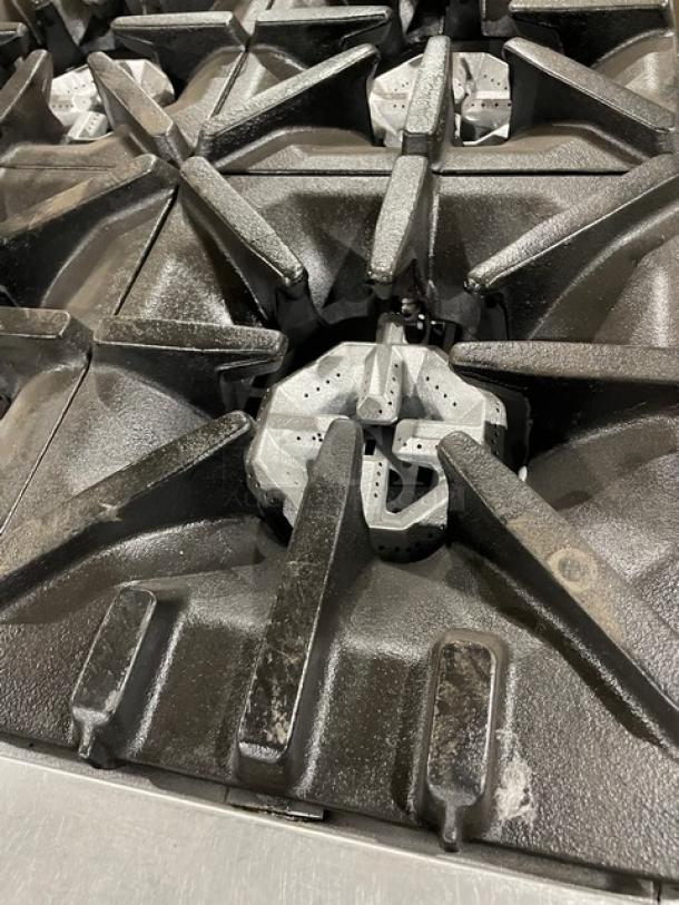 U.S. Range commercial stainless steel 6-burner gas range with enclosed cabinet base and casters, slightly worn condition.