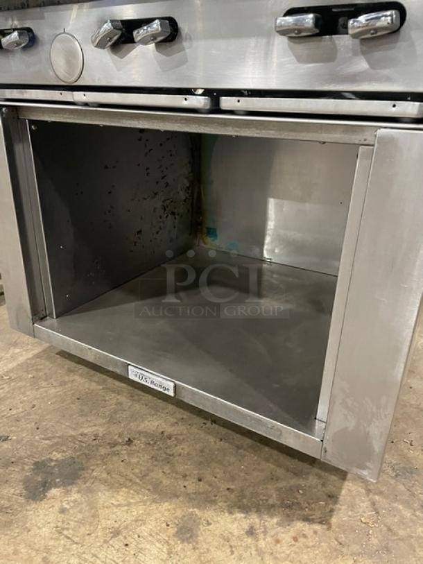 U.S. Range stainless steel 6-burner gas range with enclosed dry cabinet, on casters. Good condition with visible branding.