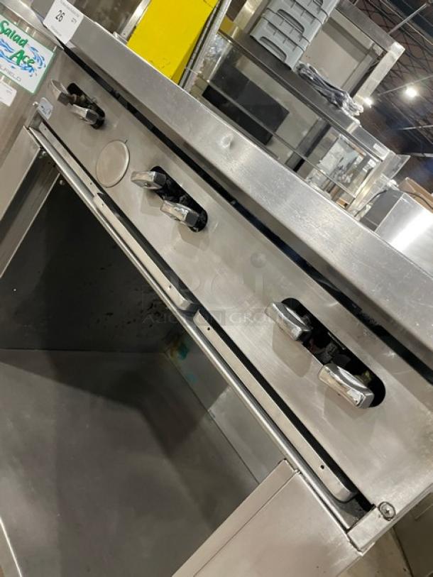 U.S. Range stainless steel 6 burner gas range with enclosed dry cabinet base on casters. Visible controls and sturdy construction.