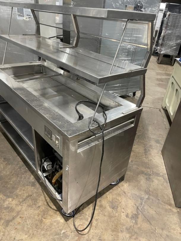 Precision stainless steel cold food/salad bar, model SST2024RTNYC, with overhead shelf, sneeze guard, cabinet base, on casters.