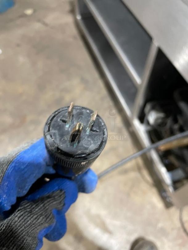 Plug of Precision SST2024RTNYC refrigerated cold food bar on casters, showing 3-prong configuration for 120V connection.