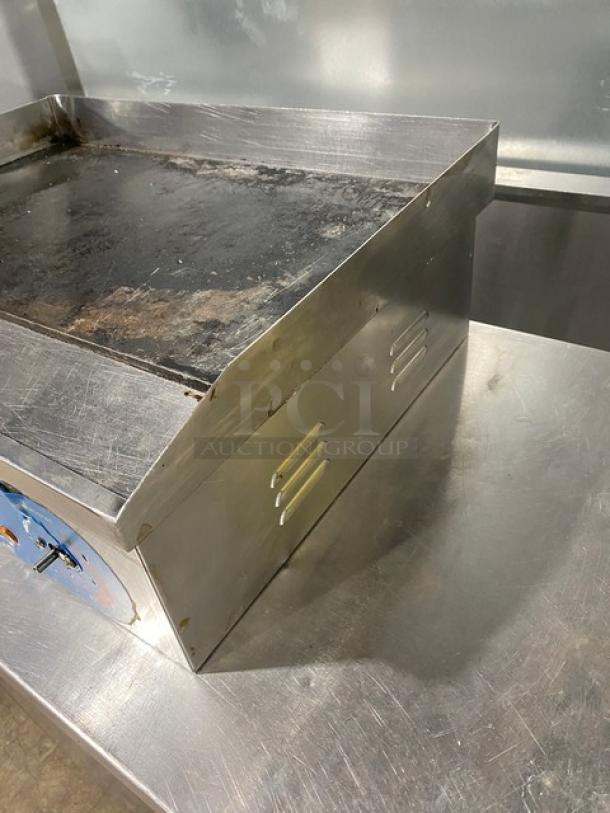 Commercial stainless steel electric countertop flat griddle with back and side splash in used condition. Sturdy design.