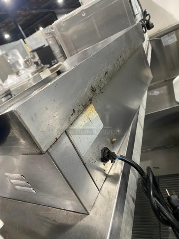 Commercial stainless steel electric griddle with back and side splash. Some visible wear and power cord attached. Ideal for countertop use.