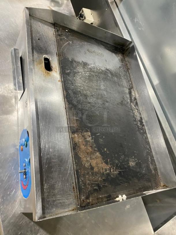 Commercial stainless steel electric flat griddle with back and side splash. Used condition with visible wear.
