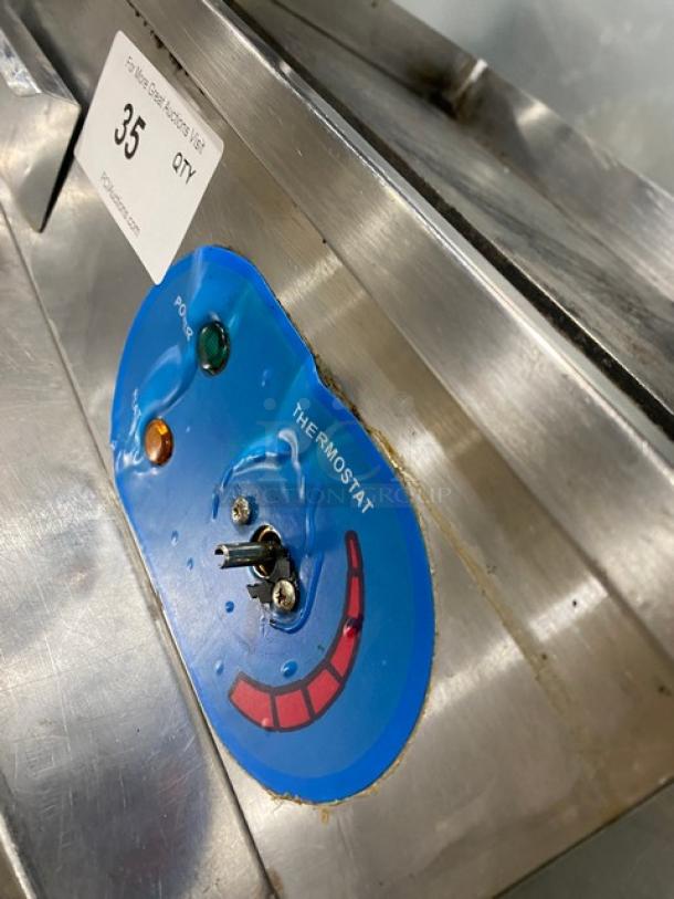 Commercial stainless steel electric countertop flat griddle featuring back and side splash, with thermostat controls.