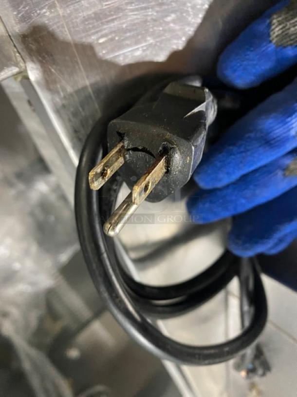 Commercial stainless steel electric griddle with back and side splash, showing power cord with three-prong plug.