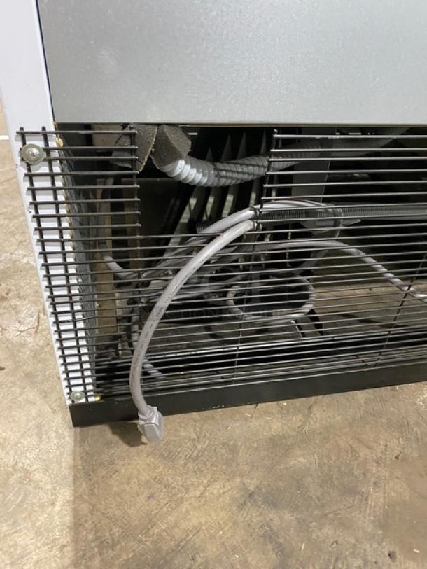 Turbo Air TGM47SDW merchandiser refrigerator back view, showing wiring and metal grates. Energy Star certified, model TGM-47SDW.