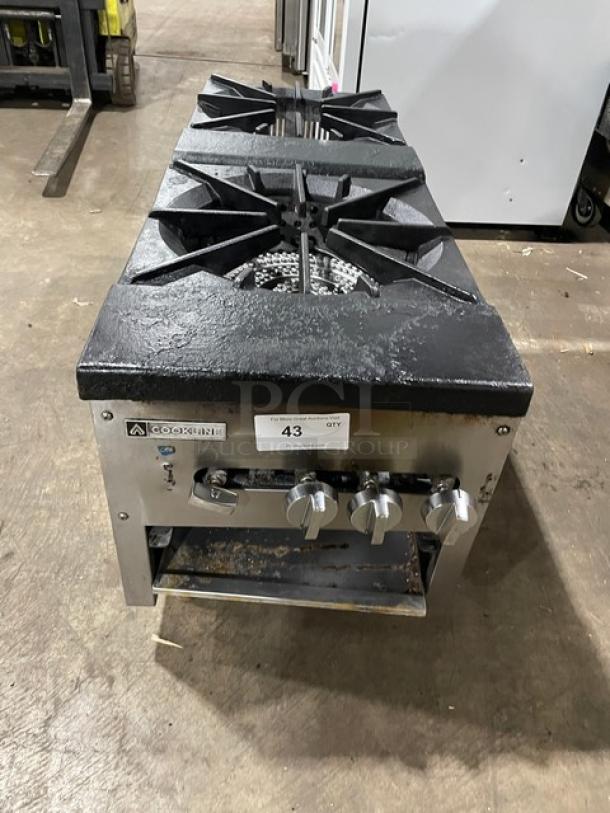 Cookline stainless steel gas double burner stock pot range, on legs, with control knobs and brand label visible.