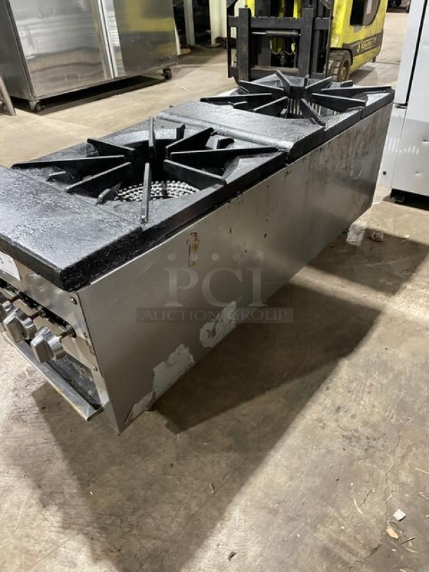 Cookline commercial stainless steel double burner stock pot range, gas powered, on legs, showing visible wear and marks.
