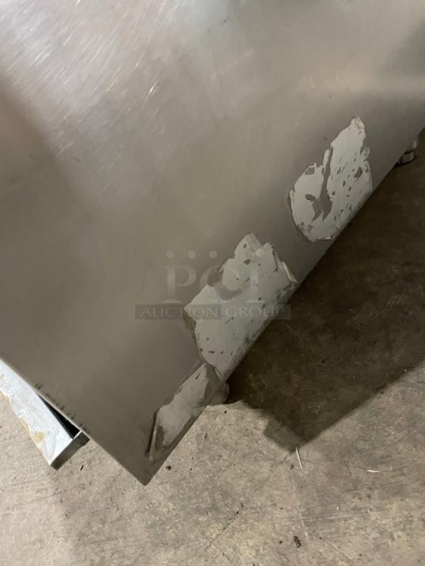 Cookline stainless steel gas-powered double burner stock pot range, on legs, showing signs of paint wear.