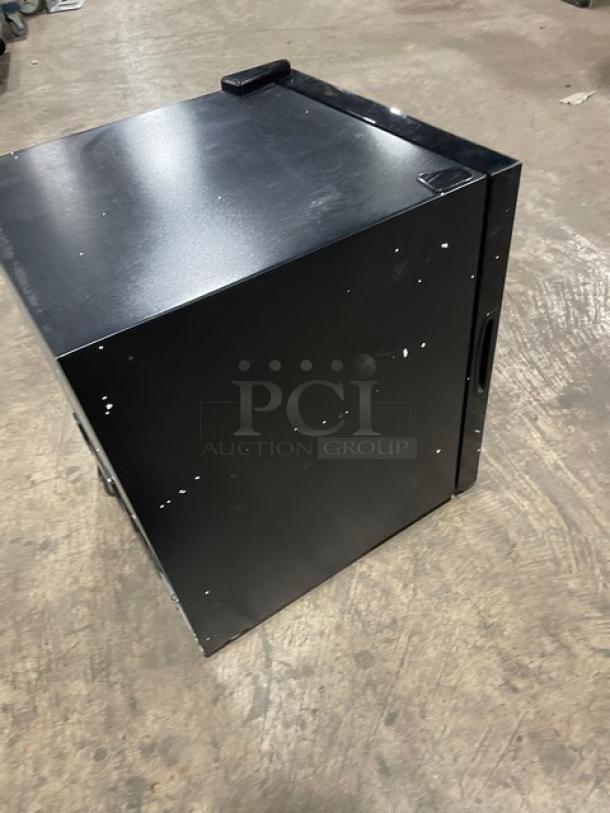 Schmecke 12-bottle wine cooler, black, single glass door, chrome-plated wired rack, visible wear on exterior.