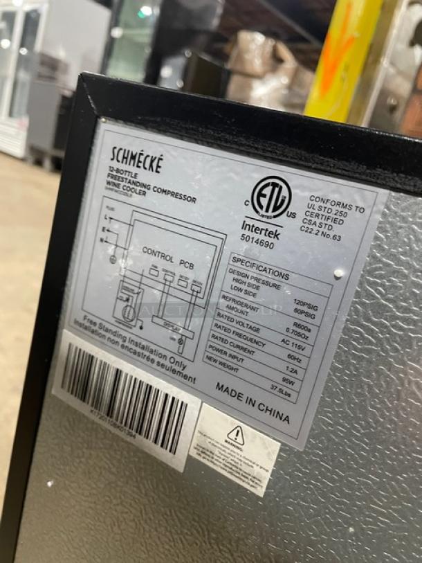 Schmecke 12-Bottle Wine Cooler, black, single glass door, chrome-plated wired rack, 115V, free-standing. ETL certified label visible.