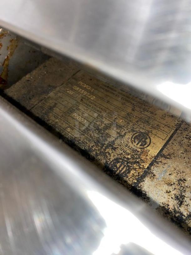 Imperial PCVG1 convection oven label, showing model and serial number, partially obscured, on worn stainless steel.