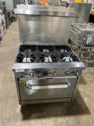 Qualite commercial stainless steel 6-burner range/oven with backsplash, overhead salamander shelf, and wired rack.