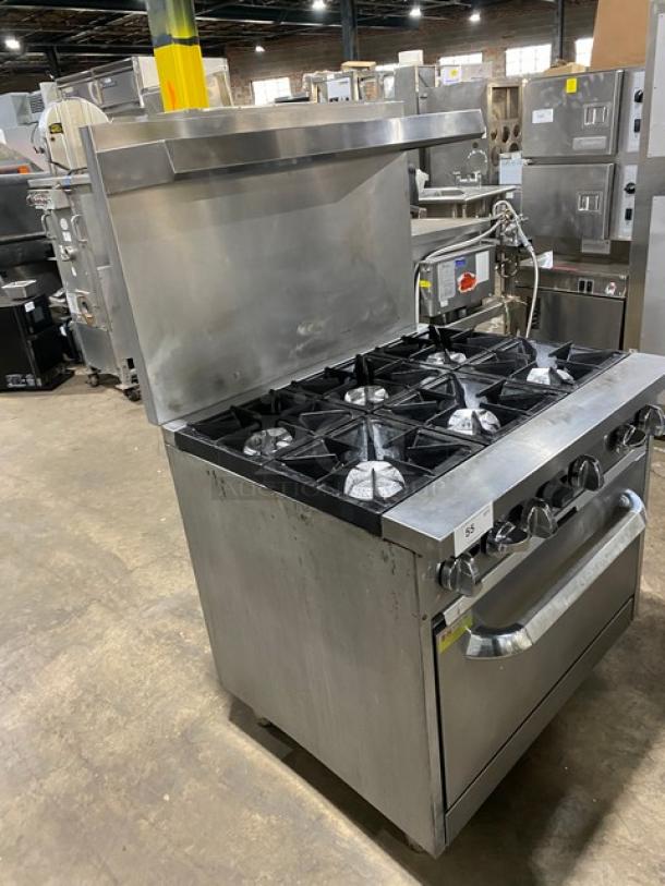 Qualite commercial stainless steel 6-burner gas range/oven combo with backsplash, overhead salamander shelf, and wired oven rack.