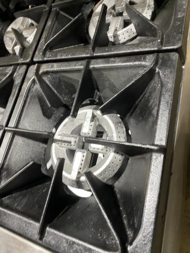 Qualite stainless steel gas 6-burner range with oven, backsplash, salamander shelf, wired rack, and legs. Excellent condition.