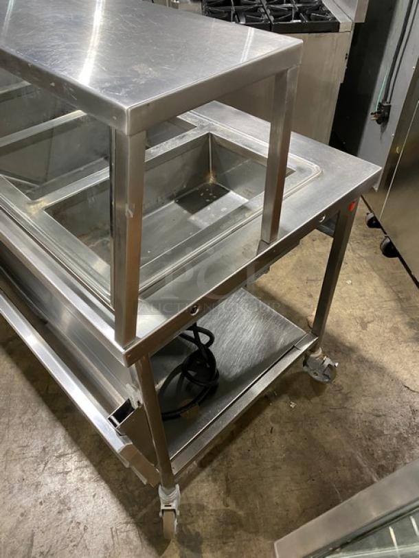 Atlas Metal WIH-D&M-4 stainless steel electric 4-well hot food table with sneeze guard, 208V, on casters.