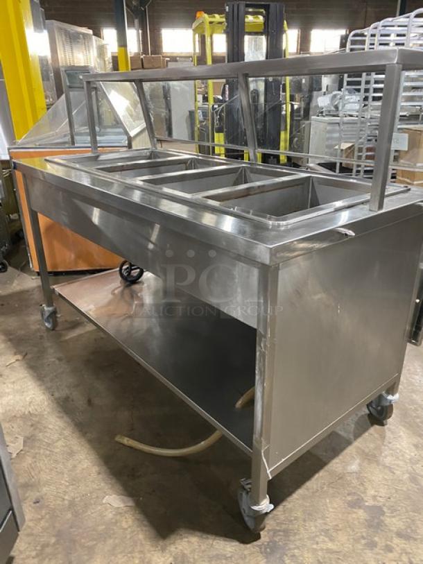 Atlas Metal WIHD&M4 stainless steel 4-well hot food table with sneeze guard, electric-powered, on casters, model SN: 14063336A.