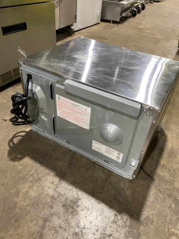 Menumaster RFS12TSW commercial stainless steel countertop microwave oven with digital controls, 120V, power cord visible.