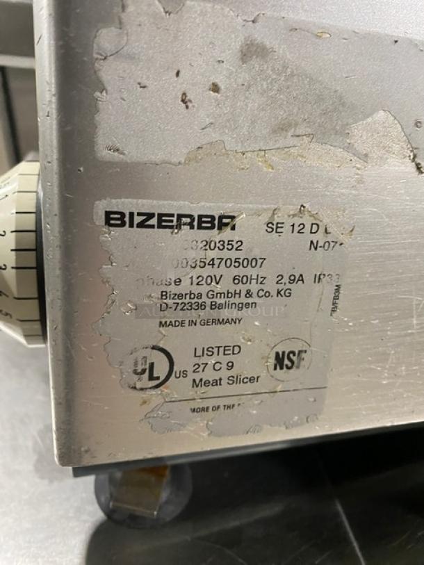 Bizerba SE12D electric deli meat slicer, heavy-duty countertop model on legs. Features 120V power, visible wear on label.