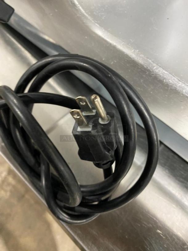 Electric cord of Bizerba SE12D deli meat slicer, showing a standard 120V plug. Rugged condition, ideal for commercial use.