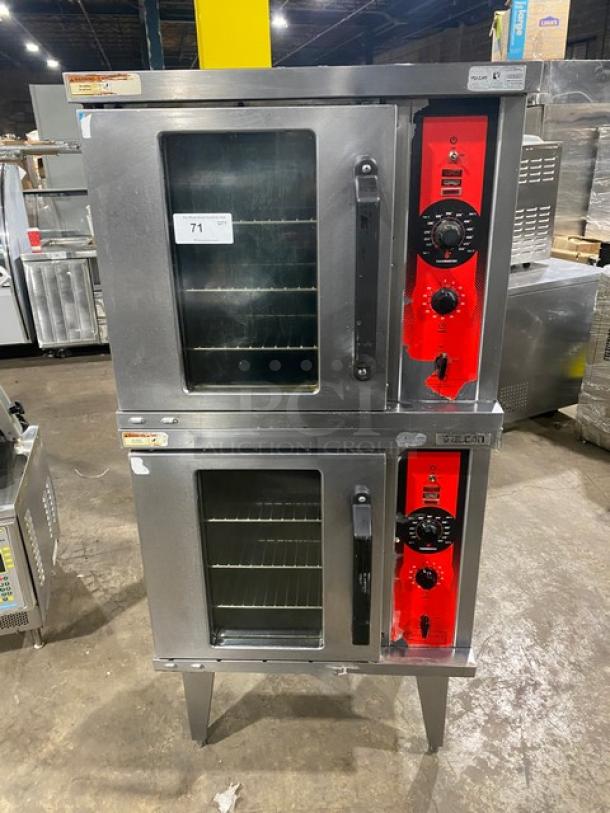 Vulcan commercial stainless steel gas-powered double stacked convection oven with wired rack, on legs, red control panels.