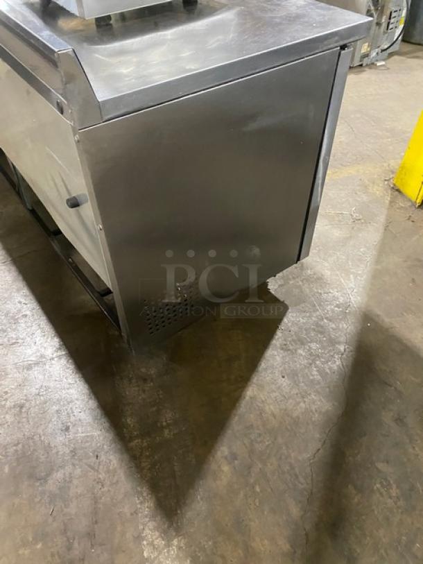 True TWT-72 stainless steel 3-door worktop refrigerator with upturned backsplash, Energy Star certified, on casters.