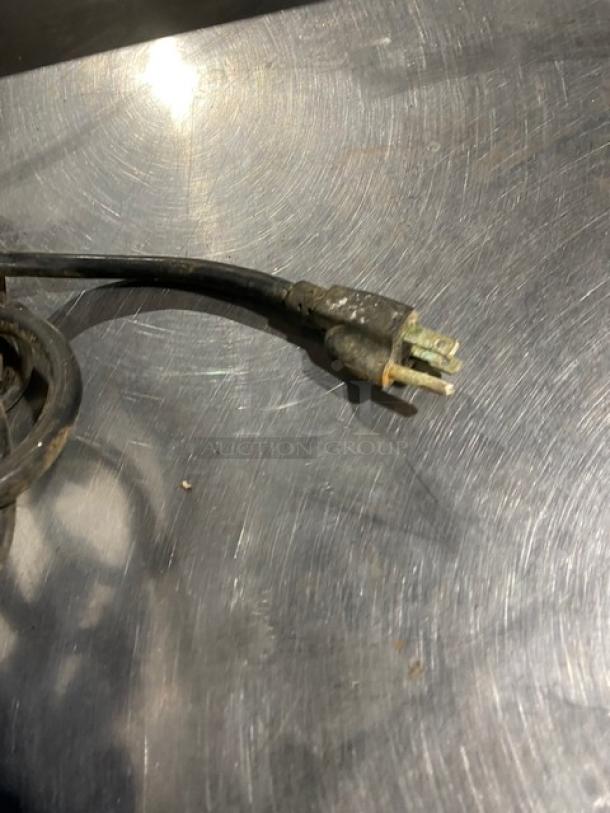 Close-up of a Cooler Depot BQL112Y ice cream machine power cord, showing visible wear on a stainless steel surface.