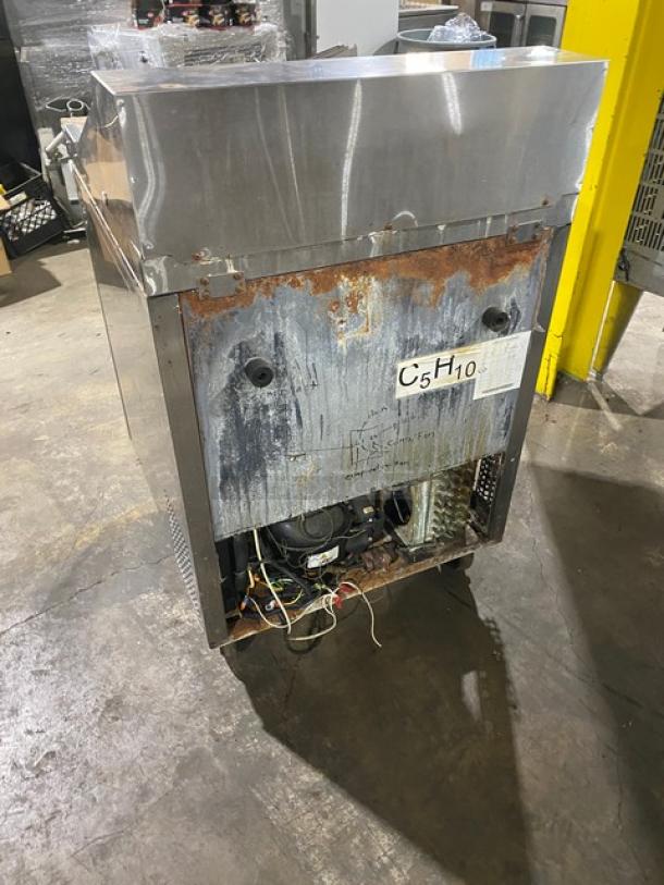 Migali stainless steel refrigerated bain marie prep table with cutting board, poly-coated rack, and casters. Signs of rust and wear.